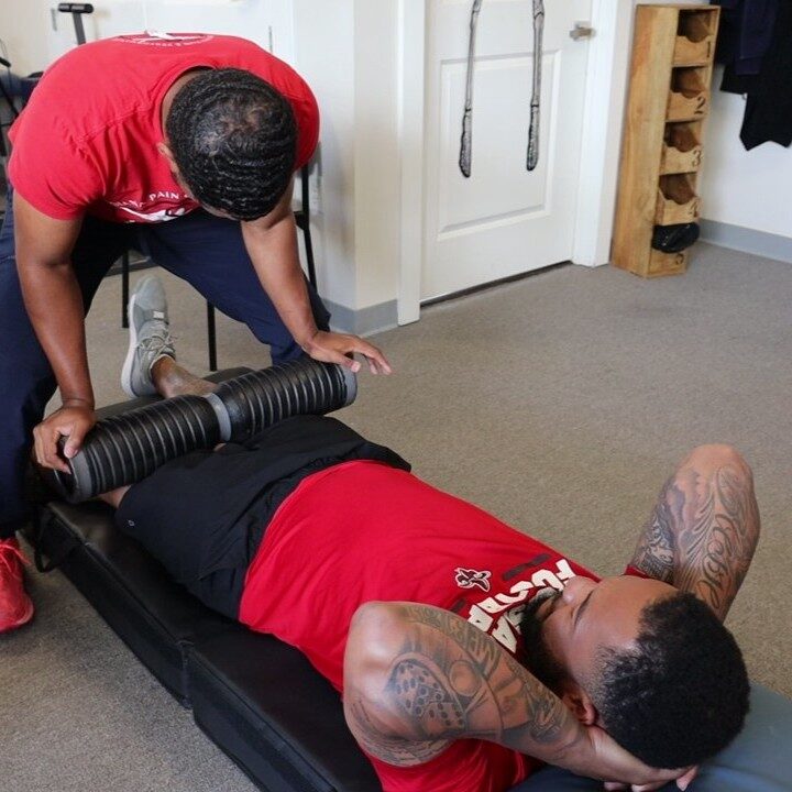 Athlete performing foam roll recovery exercise as part of running rehabilitation