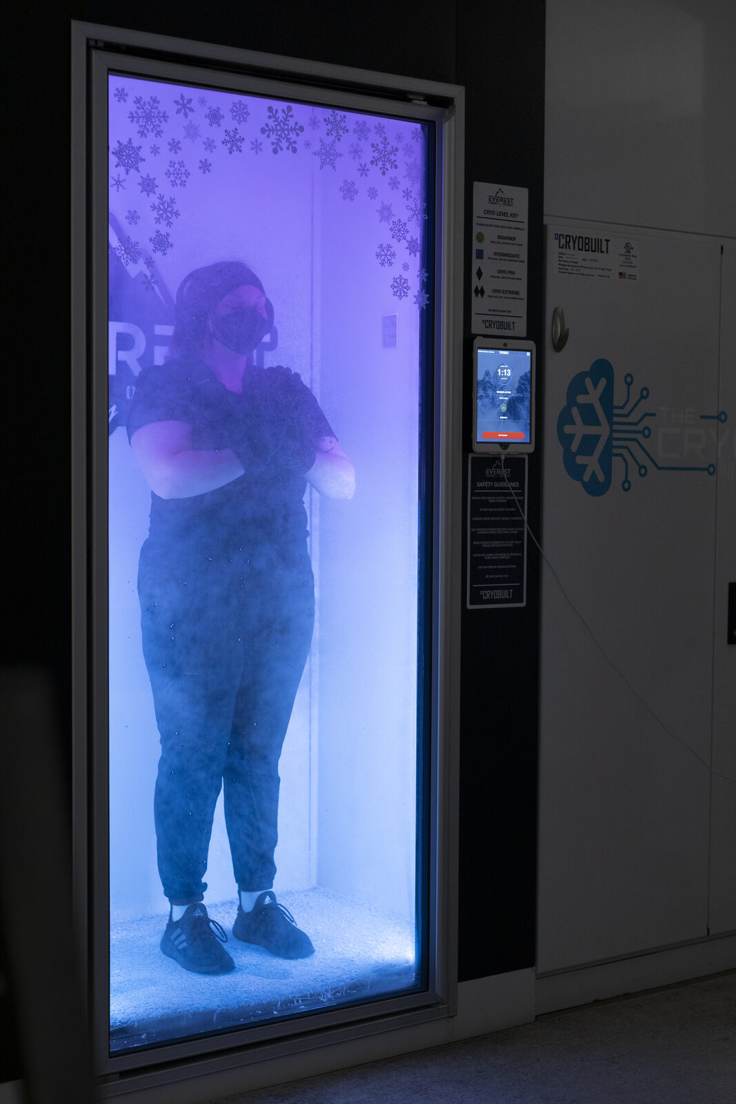 A patient standing in a whole body cryotherapy chamber at HERO Health Spa