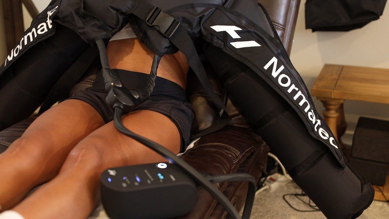 Patient using NormaTec compression leg sleeves during a recovery session