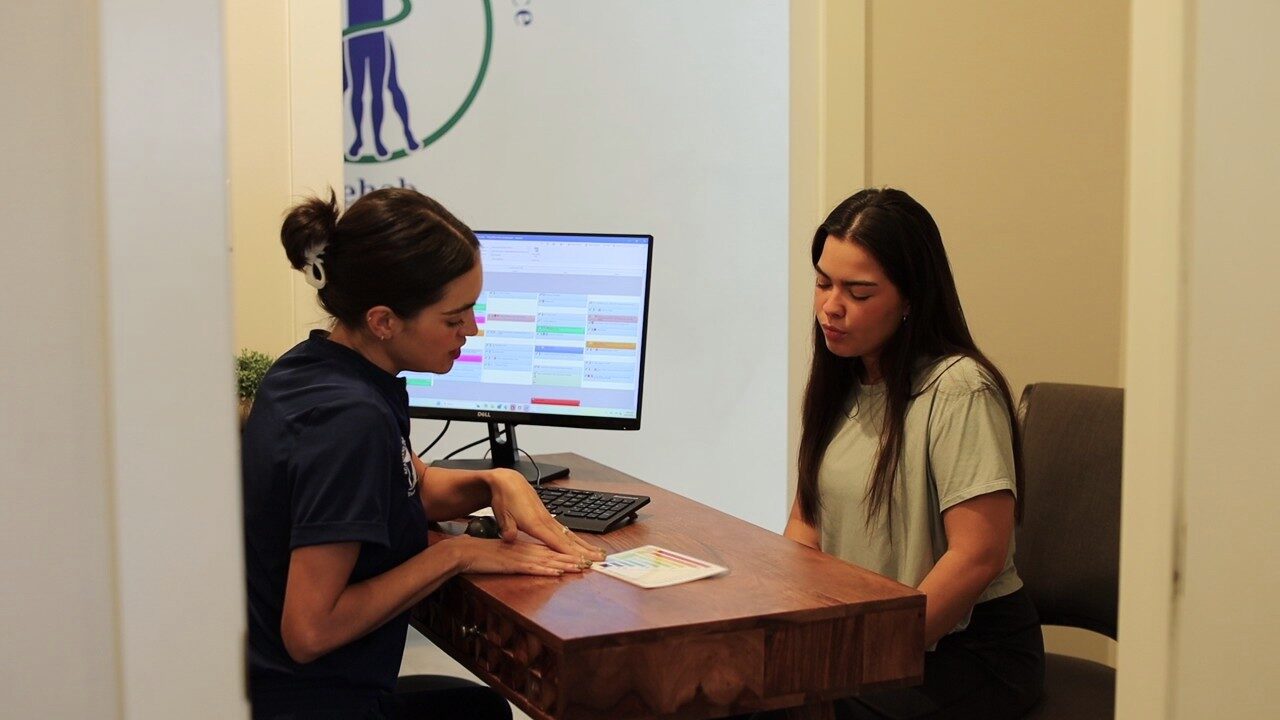 A staff member checking in a new patient at the front desk