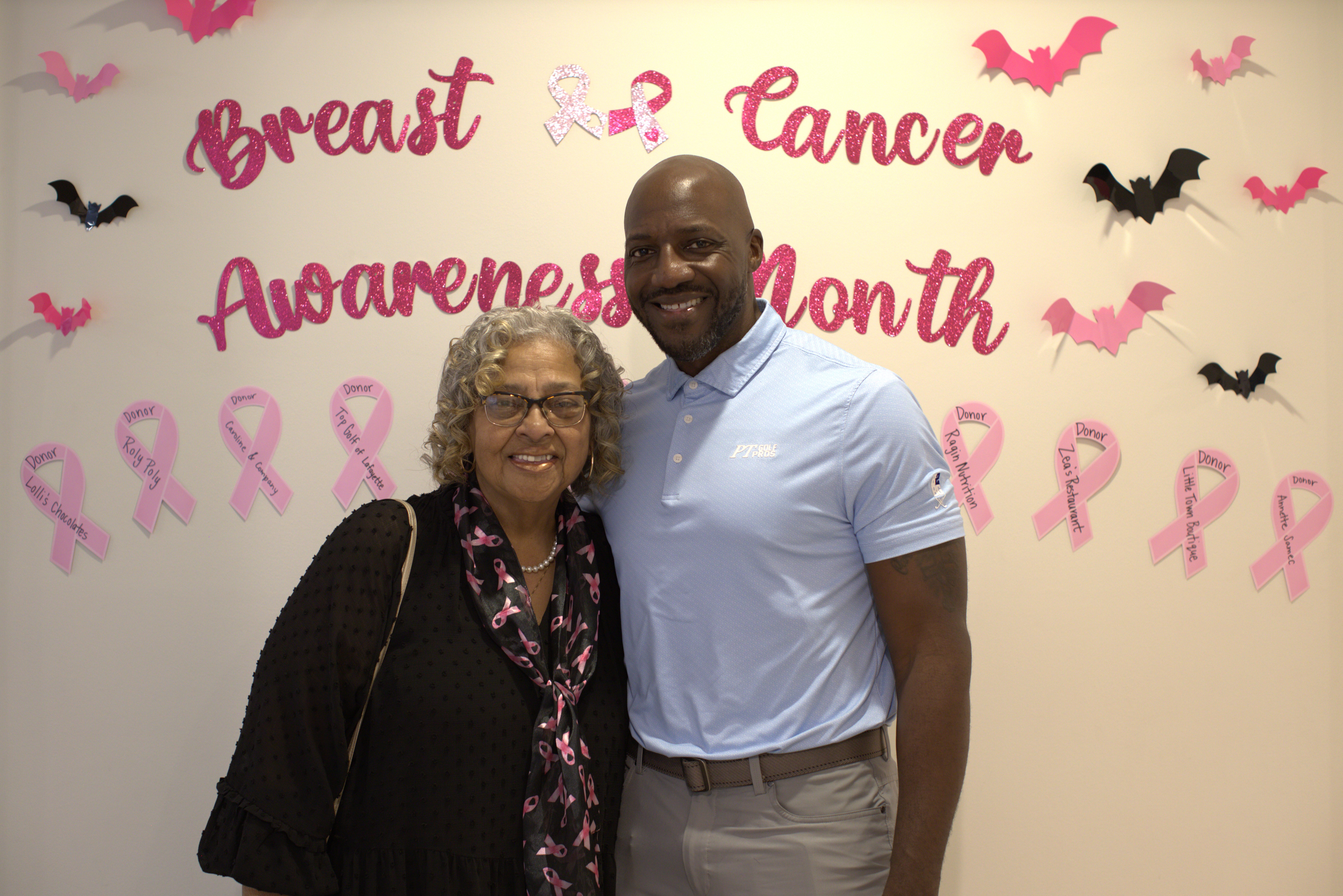 Community members standing in front of a Breast Cancer Awareness Month display